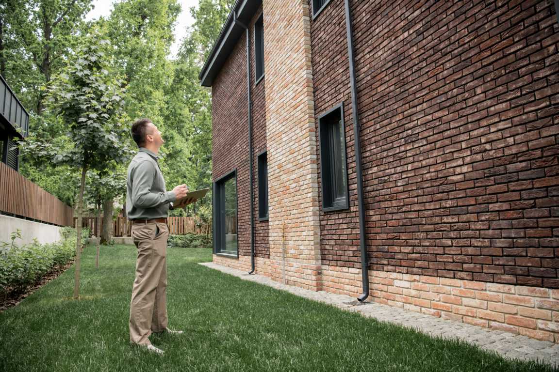 Immobilien im Frühjahr: Check für Eigentümer, Käufer und Verkäufer. Überprüfung der Ausssenfassade auf Beschädigungen beim Frühkajrs-Check der Immobilie.